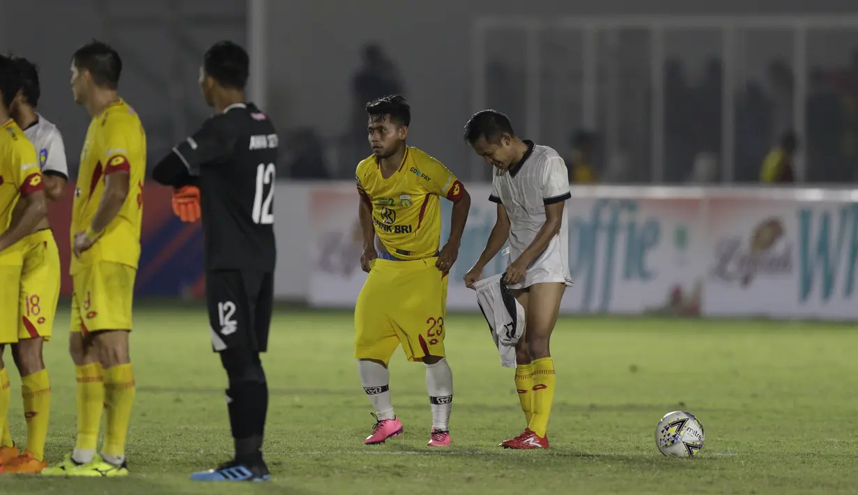Gelandang Madura United, Andik Vermansah, bertukar jersey dan celana dengan gelandang Bhayangkara FC, Wahyu Suboseto, pada laga Liga 1 2019 di Stadion Madya, Jakarta, Senin (5/8). Kedua tim bermain imbang 1-1. (Bola.com/M iqbal Ichsan)