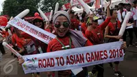 Peserta Parade Asean Games 2018 Jakarta - Palembang membawa baner bertuliskan "Road To Asian Games 2018, Jakarta, Minggu (27/12/2015). Indonesia akan menjadi tuan rumah perhelatan Asian Games 2018 mendatang. (Liputan6.com/Johan Tallo)