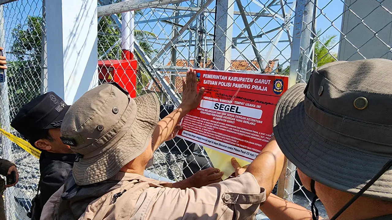 Pj Bupati Garut Barnas Adjidin, bersama Kasatpol PP Garut Usep Basuki Eko memimpin penyegelan tower telkomsel ilegal di Kecamatan Caringin, Sabtu (22/6/2024). (Liputan6.com/Jayadi Supriadin)
