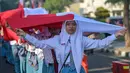 Ribuan pelajar turun ke jalan untuk mengikuti prosesi upacara dan arak-arakan bendera Merah Putih. (Juni KRISWANTO/AFP)