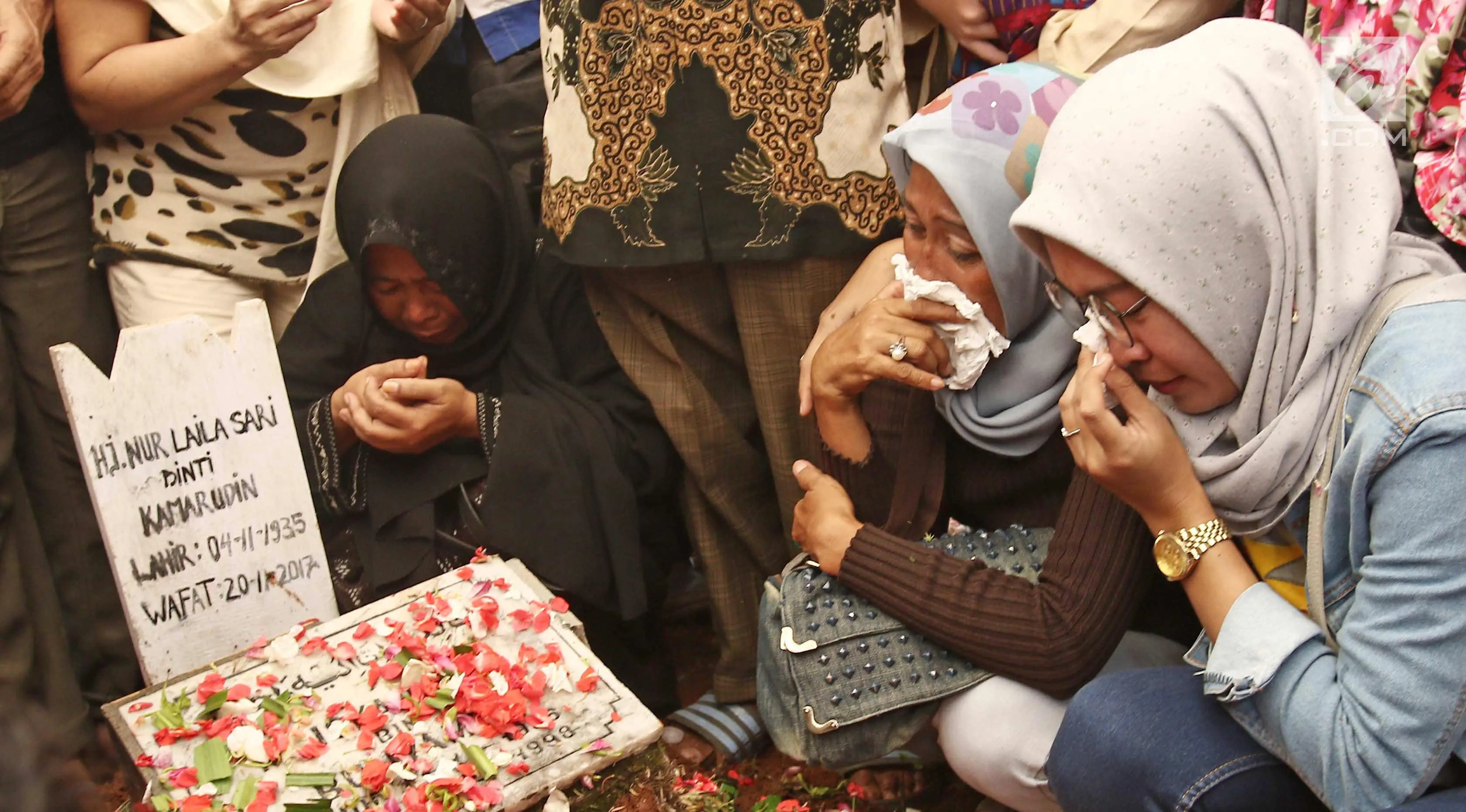 Kerabat dan keluarga menangis  saat  dipemakaman Laila Sari di Tempat Pemakaman Umum (TPU) Karet Bivak, Jakarta, Selasa (21/11). Laila Sari meninggal dunia saat pulang syuting, di usai 82 tahun. (Liputan6.com/Herman Zakharia)