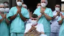 Veteran Perang Dunia II asal Brasil, Ermando Armelino Piveta meninggalkan Rumah Sakit Angkatan Bersenjata setelah pulih dari covid-19 di Brasilia, Selasa (14/4/2020). Mengenakan topi militer, kakek berusia 99 tahun tersebut mengangkat tangannya saat meninggalkan rumah sakit. (EVARISTO SA/AFP)