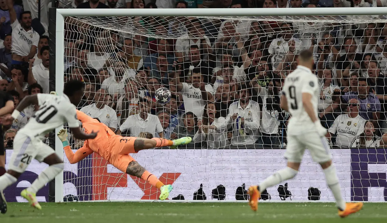 Penjaga gawang Manchester City, Ederson Moraes (tengah), gagal menepis tendangan pemain Real Madrid, Vinicius Junior (kiri), dalam pertandingan leg pertama Liga Champions 2022/2023 yang berlangsung di Santiago Bernabeu stadium, Rabu (10/5/2023) dini hari WIB. (AFP/Thomas Coex)