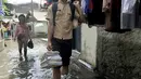 Anak sekolah melintas saat banjir menggenangi kawasan Rawa Terate, Cakung Jakarta, Rabu (30/1). Banjir yang mencapai ketinggian pinggang orang dewasa terjadi sejak dini hari. (merdeka.com/Iqbal S. Nugroho)