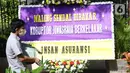Pejalan kaki melintasi karangan bunga yang terpajang di depan Pengadilan Negeri Jakarta Pusat, Senin (12/10/2020). Karangan bunga yang mengharapkan keadilan tersebut berjejer menjelang sidang vonis terdakwa kasus dugaan korupsi di PT Asuransi Jiwasraya (Persero). (Liputan6.com/Angga Yuniar)