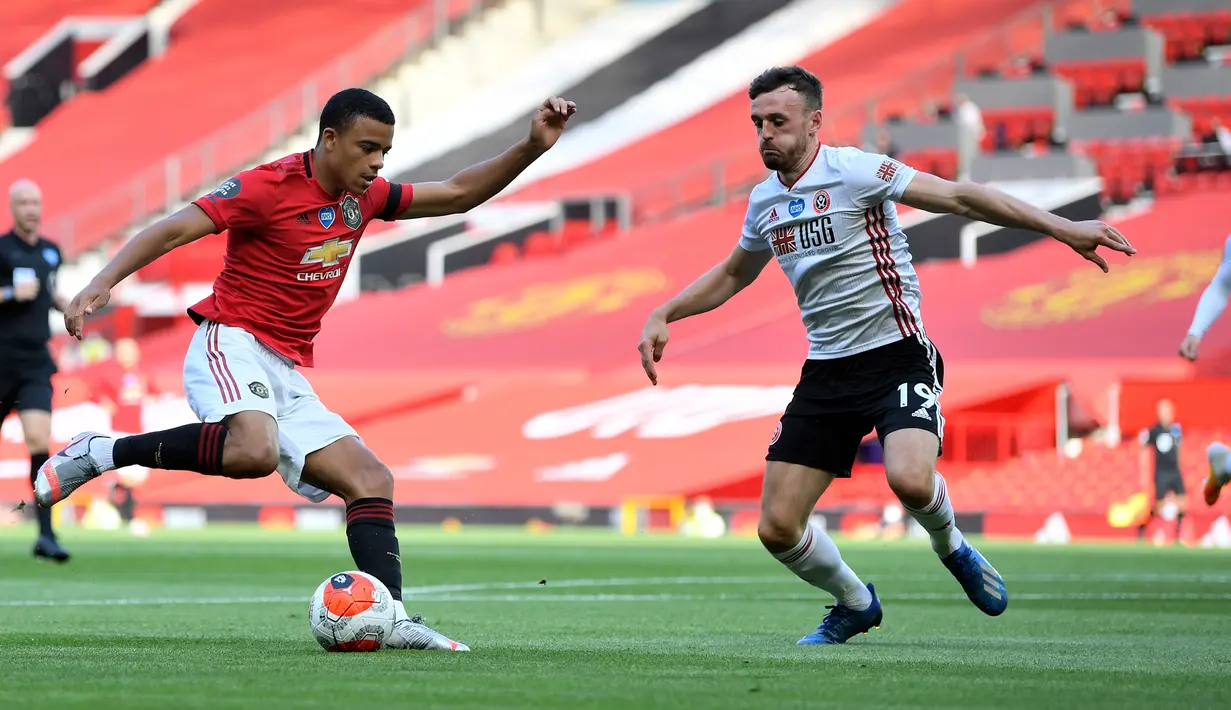 Gelandang Manchester United, Mason Greenwood berusaha melewati pemain Sheffield United, Jack Robinson pada pertandingan lanjutan Liga Inggris di Old Trafford di Manchester, Inggris (24/6/2020). MU menang telak 3-0 atas Sheffield United. (Michael Regan / Pool via AP)
