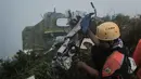 Operasi pencarian dan penyelamatan dilakukan melalui kombinasi jalur udara dan darat dengan mempertimbangkan kondisi cuaca di area pegunungan. Tampak dalam foto, seorang personel pencarian dan penyelamatan membawa puing-puing pesawat turboprop Indonesia Air Transport berjenis ATR 42-500 di Gunung Bulusaraung, Sulawesi Selatan pada Minggu 18 Januari 2026. (Muchtamir Zaide/AFP)