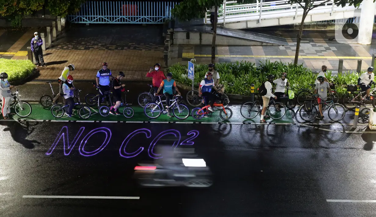 Pegiat bersepeda dan aktivis pecinta lingkungan saat aksi gowes Kelap Kelip Jakarta Night Ride #NOP26 di Jalan Jenderal Sudirman, Jakarta, Jumat (26/11/2021). Aksi ini mendorong pemimpin dunia berkomitmen meningkatkan tingkat bersepeda untuk mengurangi emisi karbon. (Liputan6.com/Helmi Fithriansyah)