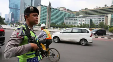 Anggota kepolisian bersenjata laras panjang berjaga di kawasan Bundaran HI, Jakarta, Jumat (15/1).  Pasca-teror di kawasan Sarinah, Jalan MH Thamrin, Polri meningkatkan status keamanan Indonesia menjadi siaga satu. (Liputan6.com/Faizal Fanani)