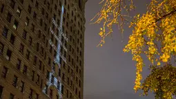 Sebuah proyeksi Menara Eiffel ditampilkan di sisi bangunan Flatiron New York City, Rabu (18/11). Gambar yang menampilkan tulisan She is tossed by waves but does not sink itu bentuk solidaritas terkait serangan teror Paris. (Andrew Burton/Getty Images/AFP)