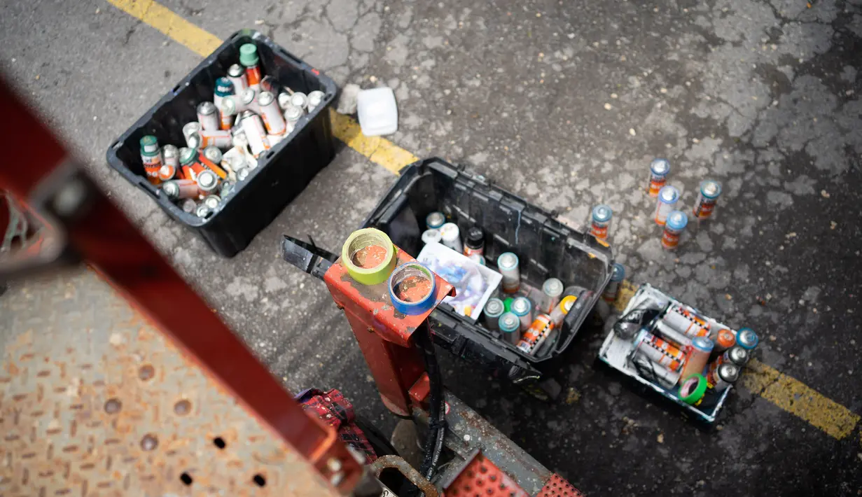 Cat semprot diletakkan pada bagian bawah lift gunting yang digunakan oleh seniman saat Festival Mural Montreal di Quebec, Kanada, 16 Juni 2022. Pengunjung dapat melihat lebih dari 100 mural masa lalu dan baru di lingkungan pusat kota metropolis berbahasa Prancis yang dilukis oleh seniman dari Kanada dan seluruh dunia. (Paola Chapdelaine/AFP)