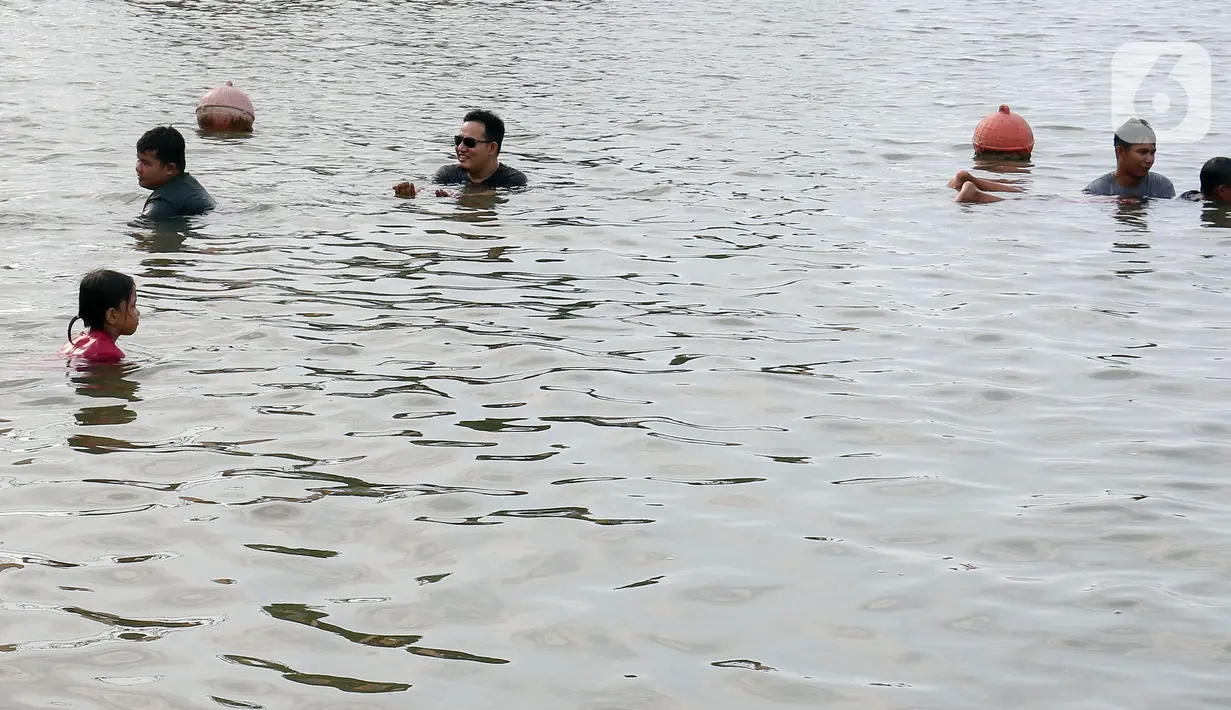 Para pengunjung antusias bermain pasir dan berenang. (Liputan6.com/Herman Zakharia)