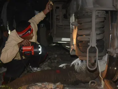 Petugas memeriksa kondisi gajah betina yang tertabrak kereta penumpang di suaka margasatwa Mahananda, India, Selasa (15/12). Gajah tewas seketika setelah tubuhnya terlindas roda kereta. (AFP PHOTO/Diptendu Dutta)