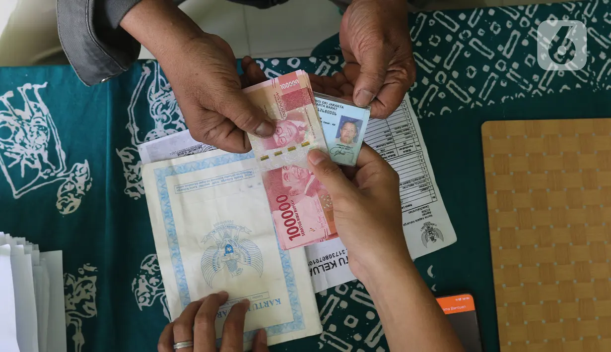 Warga menerima uang bantuan sosial tunai (BST) dari Kemensos di kawasan Kelurahan Kembangan, Meruya, Jakarta Barat, Minggu (25/07/2021). Kementerian Sosial (Kemensos) melalui PT Pos Indonesia mulai menyalurkan BST yang dirapel dua bulan sekaligus dengan total Rp600ribu (Liputan6.com/Herman Zakharia)