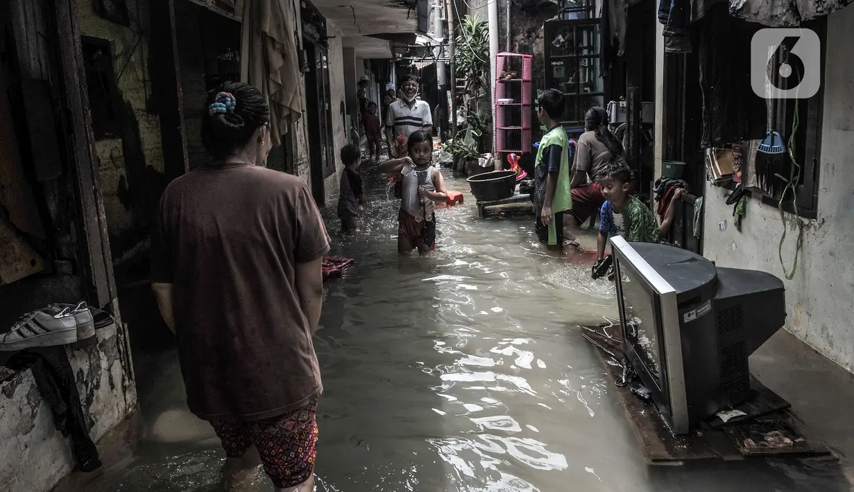 Anak-anak bermain air saat banjir merendam permukiman warga di kawasan Kemang Timur XI, Jakarta Selatan, Minggu (21/2/2021). Warga berharap pemerintah segera memperbaiki longsor agar banjir tidak berkepanjangan. (merdeka.com/Iqbal S. Nugroho)