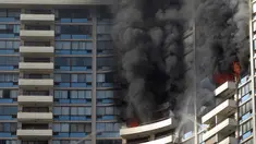 Petugas pemadam kebakaran menyemprotkan air untuk memadamkan api saat terjadi kebakaran di apartemen Marco Polo, Honolulu (14/7). Setidaknya tiga orang tewas akibat kebakaran yang terjadi di apartemen tersebut. (AP Photo / Marco Garcia)
