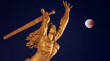 Fenomena gerhana bulan total "Micro Blood Moon" terlihat di dekat patung Dewi Kemenangan di Warsawa, Polandia, Jumat (27/7). Gerhana bulan yang terlama pada abad ini dapat disaksikan di seluruh dunia dengan mata telanjang. (AP/Alik Keplicz)