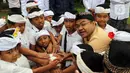 Deputi Bidang SDM, Teknologi, dan Informasi Kementerian BUMN, Tedi Bharata (kedua kiri) menyerahkan bola untuk anak-anak desa Penglipuran, Kabupaten Bangli, Bali, Kamis (17/8/2023). (Liputan6.com/Helmi Fithriansyah)