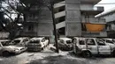 Mobil-mobil yang terbakar berdiri di luar blok apartemen di Desa Mati, timur Athena, Selasa (24/7). Tim penyelamat melaporkan menemukan lebih dari 20 jenazah berkerumun di dekat pantai. (AP Photo/Thanassis Stavrakis)