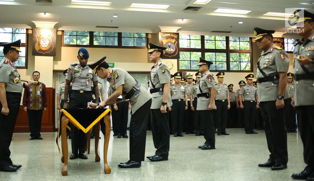 Irjen Idham Azis menandatangani dokumen serah terima jabatan disaksikan Kapolri Jenderal Tito Karnavian di Rupatama Mabes Polri, Rabu (26/7). Idham Azis dilantik sebagai Kapolda Metro Jaya menggantikan Irjen Mochamad Iriawan. (Liputan6.com/Faizal Fanani)