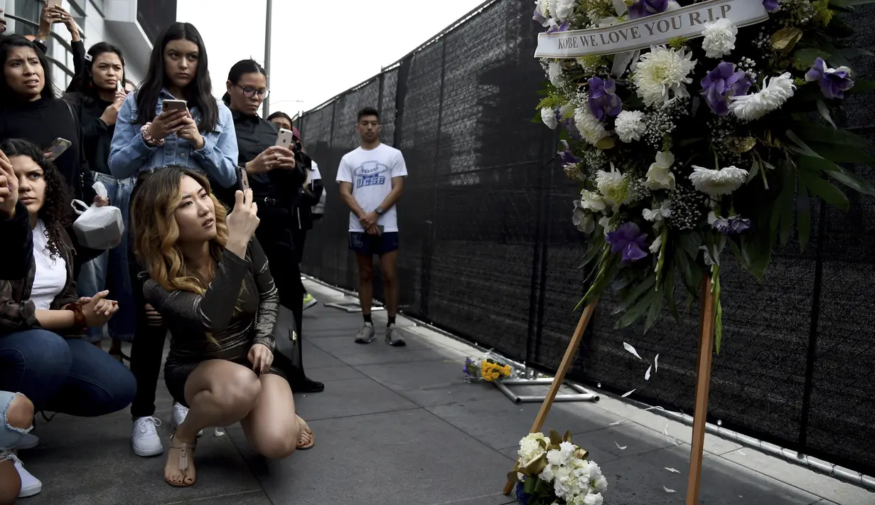 Fans Kobe Bryant berduka saat berkumpul di depan Staples Center, Los Angeles Lakers (26/1/2020). Dunia olah raga terkejut atas kabar buruk itu untuk kemudian serempak menyampaikan duka cita. (AP Photo/Chris Pizzello)