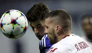 Gelandang Dinamo Zagreb Martin Baturina (kiri) berebut bola dengan pemain depan AC Milan Ante Rebic pada pekan ke-5 Grup E Liga Champions 2022/2023 di Stadion Maksimir, Rabu (26/10/2022) dini hari WIB. Meski menang, nasib Milan masih harus ditentukan di laga pamungkas karena hanya unggul satu poin dari RB Salzburg. (Damir SENCAR / AFP)