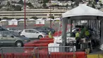 Mobil-mobil menunggu untuk mendapatkan vaksin COVID-19 di pusat vaksinasi drive-thru di City College of San Francisco di San Francisco, Senin (1/2/2021). Ketika pasokan vaksin COVID-19 meningkat, UC San Francisco memperluas upaya vaksinasi kepada mereka yang paling berisiko. (AP Photo/Jeff Chiu)
