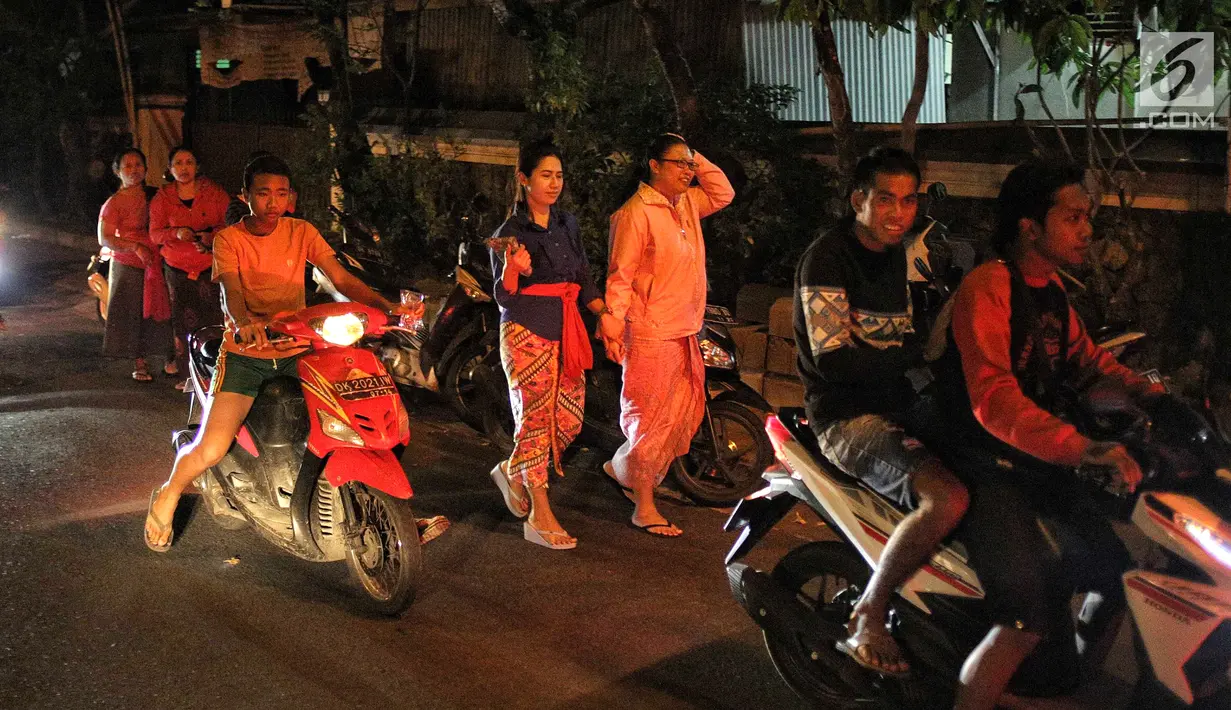 Warga berhamburan keluar rumah saat gempaberkekuatan 7 SR di Lombok dirasakan di kawasan Nusa Dua Bali, Minggu (5/8). Badan Meteorologi, Klimatologi, dan Geofisika (BMKG) menyatakan, gempa berpotensi menimbulkan tsunami. (Liputan6.com/Faizal Fanani)