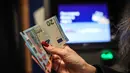Penerapan euro akan dilakukan secara bertahap. Sepanjang Januari 2026, masyarakat Bulgaria masih diperbolehkan menggunakan dua mata uang secara bersamaan, Lev Bulgaria tetap berlaku berdampingan dengan euro selama masa transisi tersebut. Tampak dalam foto, seseorang menunjukkan uang kertas euro yang ditarik dari ATM di Sofia, Bulgaria, Kamis 1 Januari 2026, saat negara tersebut bergabung dengan serikat mata uang euro. (AP Photo/Valentina Petrova)