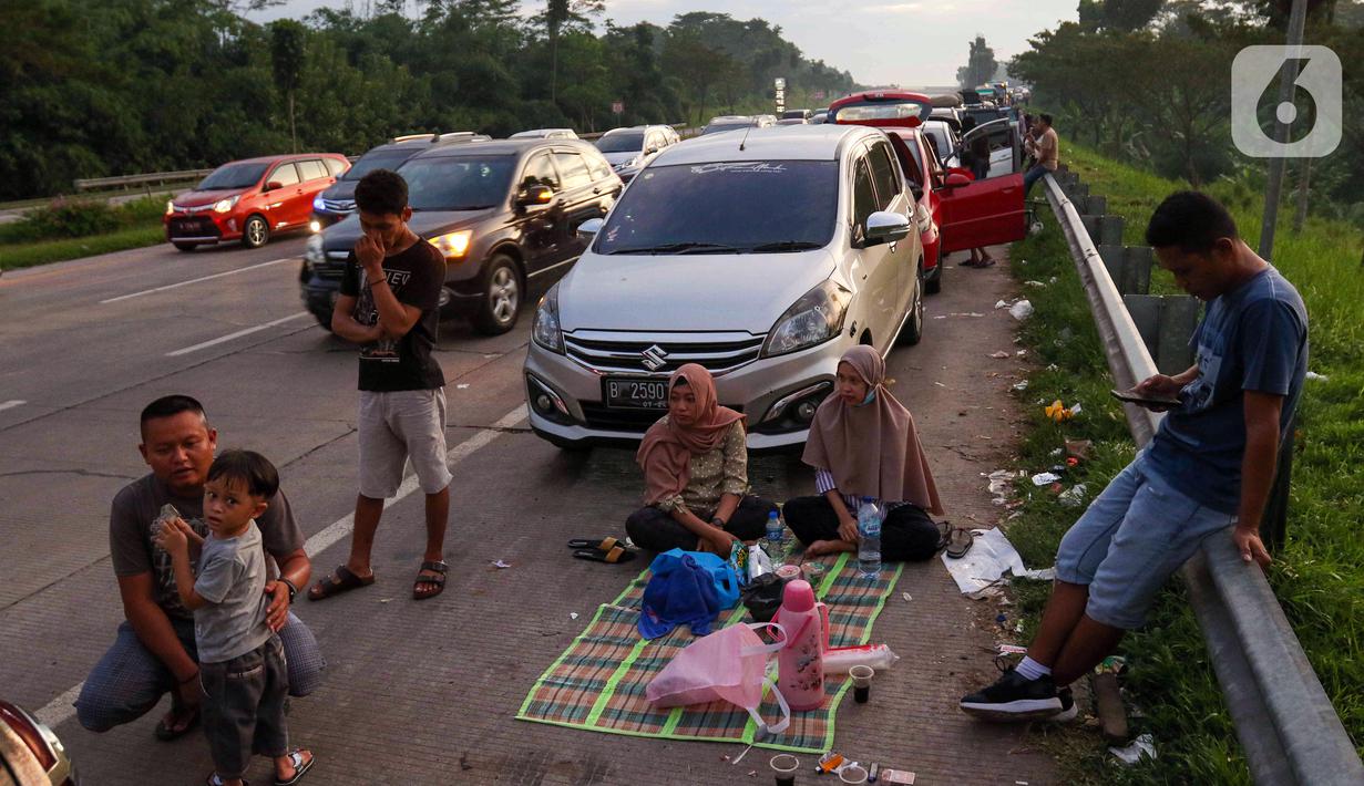<p>Sejumlah pemudik menanti waktu berbuka puasa Ramadhan sambil beristirahat di KM 102 ruas Tol Cikopo-Palimanan, Subang, Jawa Barat, Kamis (28/4/2022). Padatnya sejumlah rest area di sepanjang jalan tol Trans Jawa membuat pemudik memanfaatkan bahu jalan untuk berbuka puasa dan istirahat sejenak. (Liputan6.com/Herman Zakharia)</p>