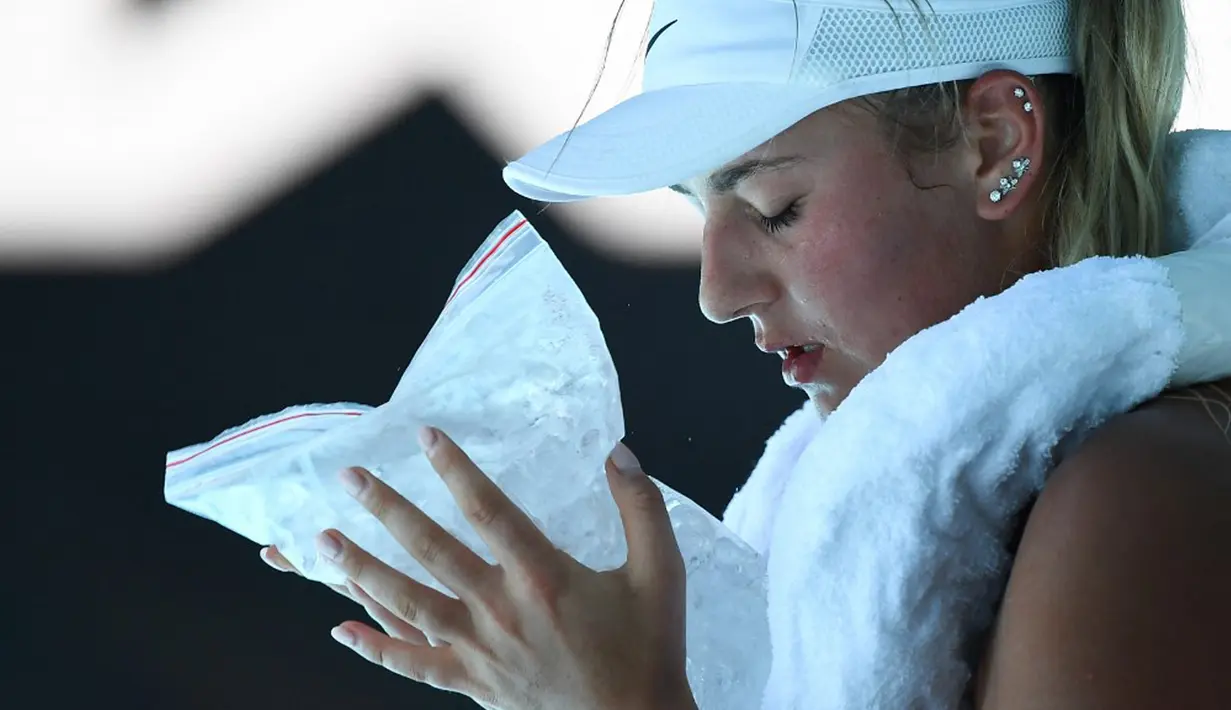 Petenis Ukraina Marta Kostyuk mendinginkan diri menggunakan kompres es saat bermain melawan petenis Spanyol Paula Badosa pada pertandingan tunggal putri turnamen tenis Australian Open di Melbourne, Australia, 21 Januari 2022. (William WEST/AFP)