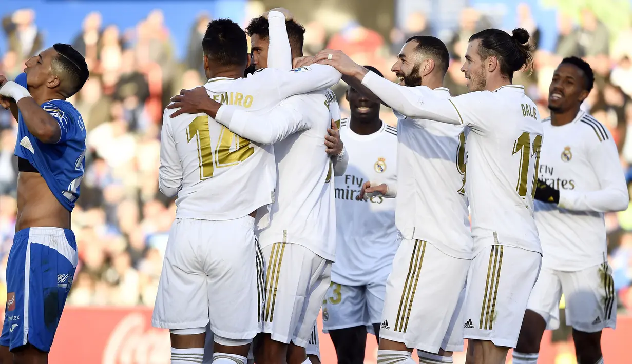 Para pemain Real Madrid merayakan gol yang dicetak Raphael Varane ke gawang Getafe pada laga La Liga Spanyol di Stadion Col Alfonso Perez, Getafe, Sabtu (4/1). Getafe kalah 0-3 dari Madrid. (AFP/Oscar Del Pozo)