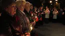 Beberapa orang memegang bunga dan lilin mengenang korban bencana nuklir Chernobyl saat upacara peringatan 28 tahun bencana nuklir Chernobyl, di Kiev, Ukraina (26/4/2014). (REUTERS/Valentyn Ogirenko)