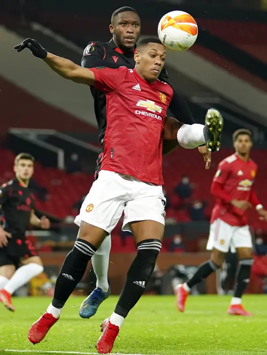 Pemain Real Sociedad Modibo Sagnan (belakang) memperebutkan bola dengan pemain Manchester United Anthony Martial pada pertandingan leg kedua babak 32 besar Liga Europa di Old Trafford, Manchester, Inggris, Kamis (25/2/2021). Laga berakhir 0-0 dan MU lolos ke babak 16 besar. (AP Photo/Dave Thompson)