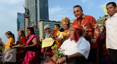 Menteri Desa, PDT dan Transmigrasi Eko Sandjojo mendorong kursi roda budayawan Wimar Witoelar saat mengikuti pawai budaya memperingati Hari Internasional Masyarakat Adat se-Dunia di Bundaran HI, Jakarta, Minggu (7/8). (Liputan6.com/Angga Yuniar)