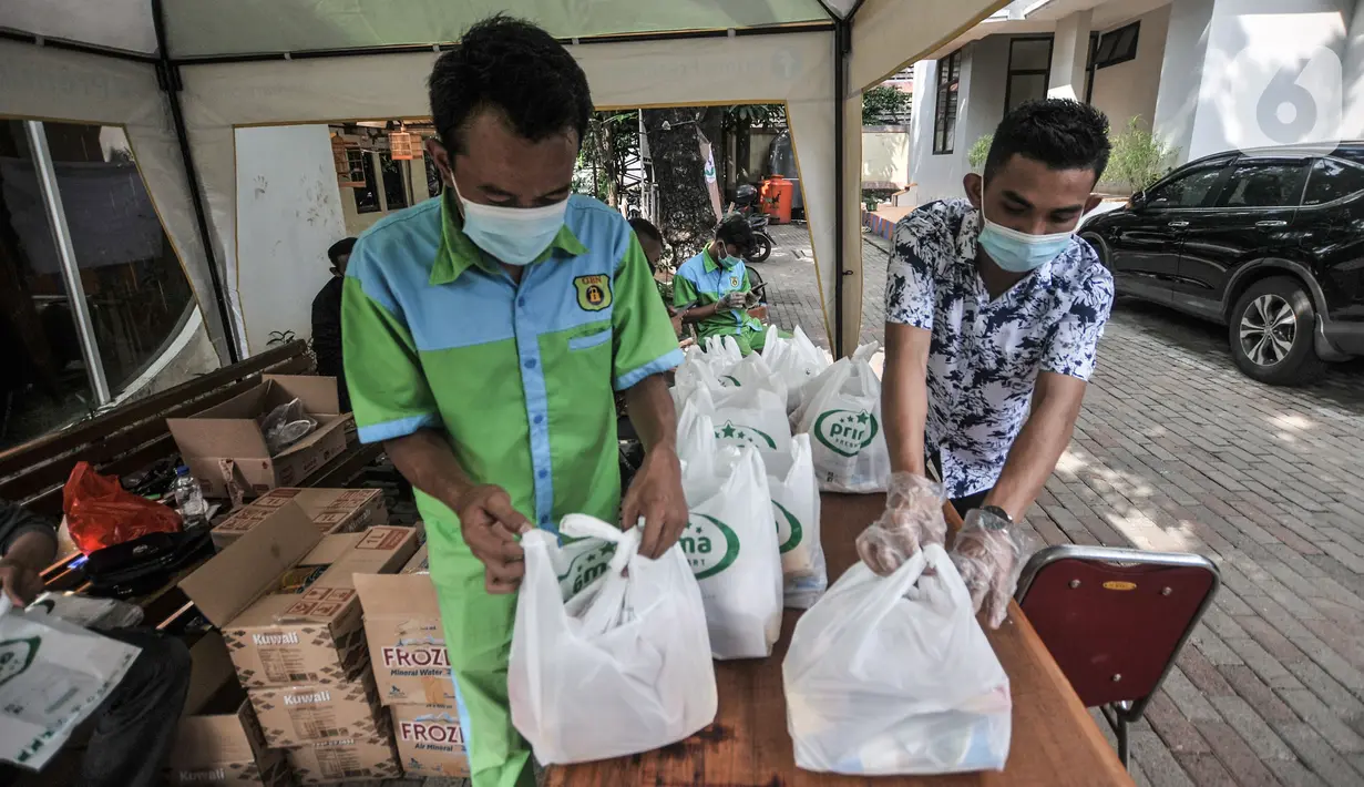 Petugas menyiapkan sembako untuk warga yang selesai mengikuti vaksinasi COVID-19 di Kantor Kelurahan Ancol, Jakarta, Kamis (17/6/2021). Pembagikan sembako gratis kepada peserta vaksinasi COVID-19 dilakukan LMK Kelurahan Ancol sebagai upaya mendorong minat warga. (merdeka.com/Iqbal S. Nugroho)