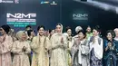 Ia nampak kenakan tunik emas berdetail gelombang dengan celana panjang dan kerudung beige [@widi.wardhana]