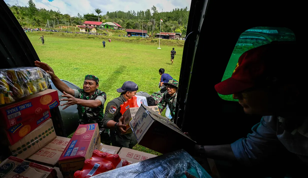 Distribusi logistik dilakukan melalui jalur udara dengan menggunakan helikopter. Tampak dalam foto, personel TNI AU menurunkan bantuan yang didistribusikan kepada warga di wilayah terdampak banjir di Kabupaten Bener Meriah, Provinsi Aceh, pada Kamis 4 Desember 2025. (CHAIDEER MAHYUDDIN/AFP)