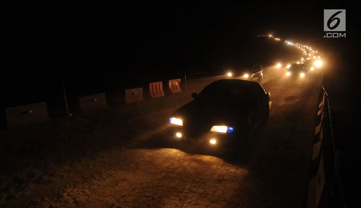 Pemudik dihimbau untuk berhati-hati saat melintasi jalan tol fungsional Brebes-Batang di Pemalang pada malam hari, Jawa Tengah, Kamis (22/6). Kondisi jalan berdebu dan tanpa lampu penerang jalan. (Liputan6.com/Gempur M Surya)