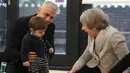 Perdana Menteri Inggris Theresa May tertawa saat bermain dengan bayi di pusat kesehatan di London, Inggris, Kamis (22/11). Sebelum menjabat sebagai PM Inggris, Theresa aktif menjadi menteri sejak tahun 2004. (Andrew Matthews/Pool via AP)
