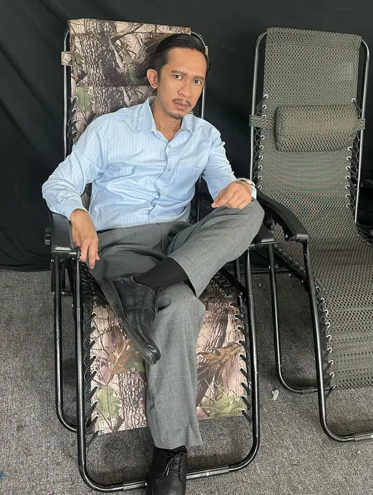 Penampilan berbeda lainnya dari Aming. Ia mengenakan atasan kemeja lengan panjang berwarna biru muda, dipadu celana panjang abu-abu dan alas kaki hitam. [Foto: Instagram/amingisback]