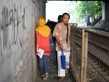 Pejalan kaki melintasi jalan setapak di sekitar Stasiun Cawang, Jakarta, Kamis (9/5). Meskipun sempit, jalan setapak tersebut masih menjadi pilihan sebagian pejalan kaki untuk menyeberangi Jalan Gatot Soebroto, dibanding harus melewati JPO yang jaraknya lebih jauh. (Liputan6.com/Immanuel Antonius)