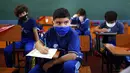 Siswa kelas empat belajar dengan mengenakan masker di sekolah teknik San Juan Bautista, Lambare, Paraguay, Rabu (17/2/2021). Beberapa SD swasta di Paraguay membuka kelas tatap muka minggu ini dengan protokol kesehatan ketat di tengah pandemi COVID-19. (AP Photo/Jorge Saenz)