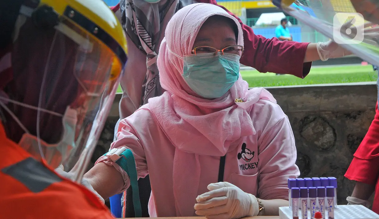 Petugas mengambil sampel darah saat melakukan rapid test pendeteksian COVID-19 kepada tenaga medis di Stadion Patriot Candrabhaga, Bekasi, Rabu (25/3/2020). Pemeriksaan hanya diperuntukan bagi tenaga medis seluruh puskesmas, dan rumah sakit yang ada di Kota Bekasi. (Liputan6.com/Herman Zakharia)