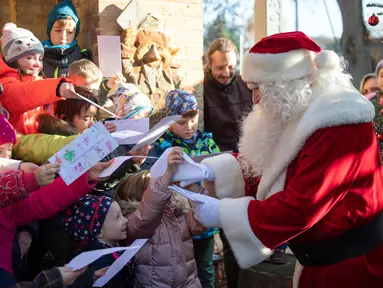 Seorang pria berpakaian Santa Claus disambut anak-anak selama pembukaan kantor surat Natal yang paling terkenal di Himmelpfort, Kamis (14/11/2019). Seperti tahun-tahun sebelumnya pada Natal kali ini Santa Klaus di Jerman sangat sibuk. (Soeren Stache/dpa via AP)