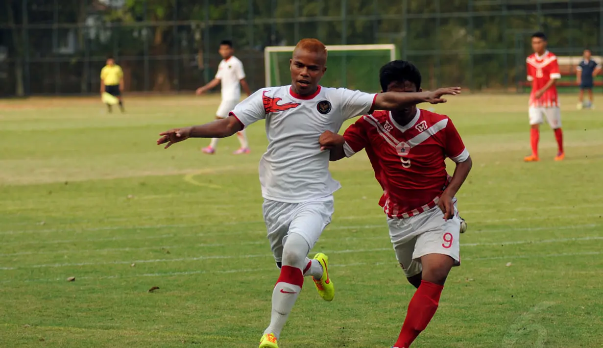 Pemain belakang Timnas Indonesia U23, Manahati Lestusen (kiri), berusaha menahan laju pemain tim Pra PON DKI Jakarta saat berlatih tanding di lapangan SPH Karawaci, Tangerang, (9/9/2014). (Liputan6.com/Helmi Fithriansyah)