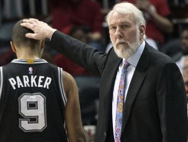 Pelatih San Antonio Spurs, Gregg Popovich memegang kepala Tony Parker usai timnya kalah dari Atlanta Hawks pada lanjutan NBA basketball game di Philips Arena, (01/01/2017). Atlanta menang 114-112. (AP/John Amis)