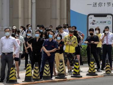 Orang-orang yang memakai masker mengantre di tempat pengujian virus corona COVID-19 pada hari ketiga tes massal untuk jutaan penduduk di Distrik Chaoyang, Beijing, China, 15 Juni 2022. (AP Photo/Mark Schiefelbein)