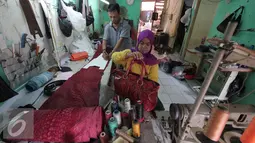 Pengerajin berbahan dasar kulit ular tengah mengukur bahan di bengkel kerja di Cibitung, Jawa Barat, Selasa (12/4). Dalam sebulan dapat memproduksi 200 buah dengan harga jual 50 ribu-8 juta. (Liputan6.com/Angga Yuniar)