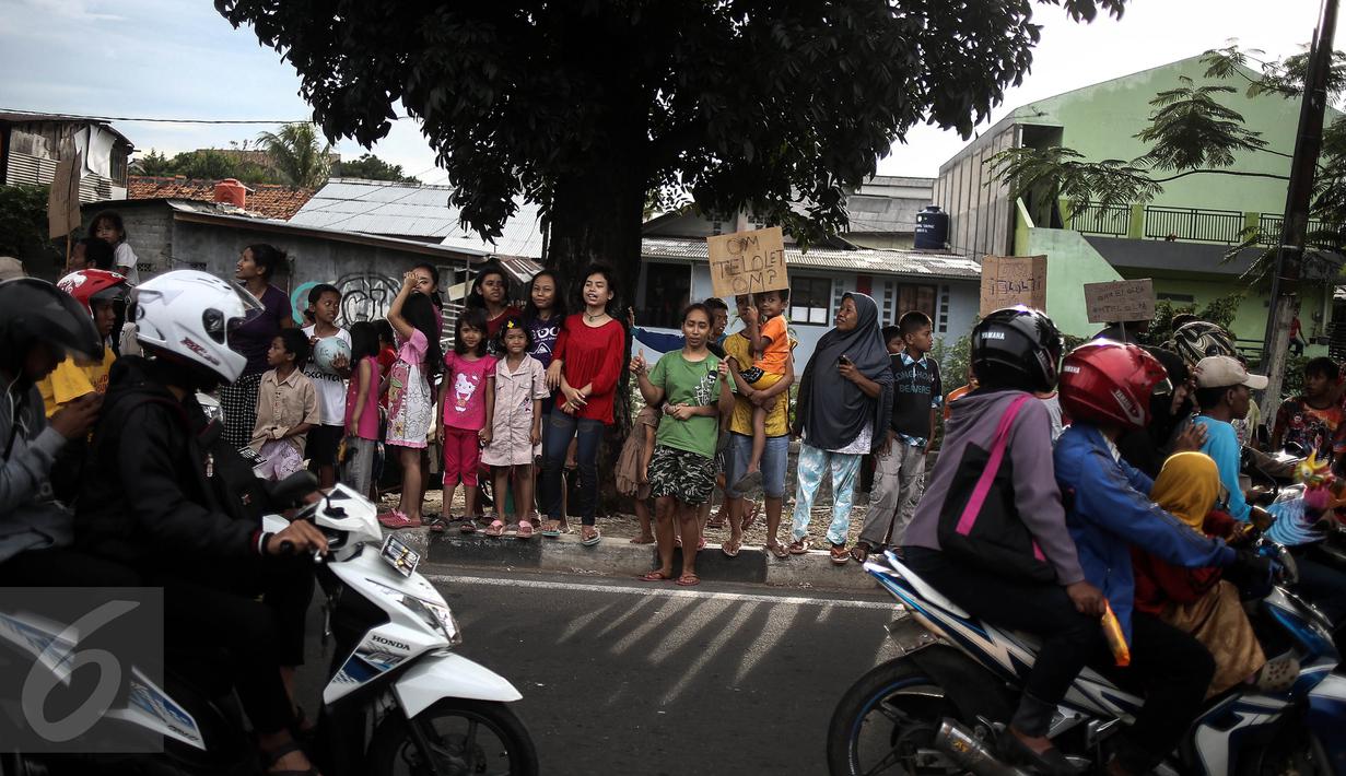 Sejumlah anak membawa spanduk pesan Om Telolet Om agar pengemudi bus membunyikan klakson di Jalan Raya Bogor, Jakarta, Sabtu (24/12). Libur sekolah dimanfaatkan anak-anak untuk berburu bus yang membunyikan klakson telolet. (Liputan6.com/Faizal Fanani)